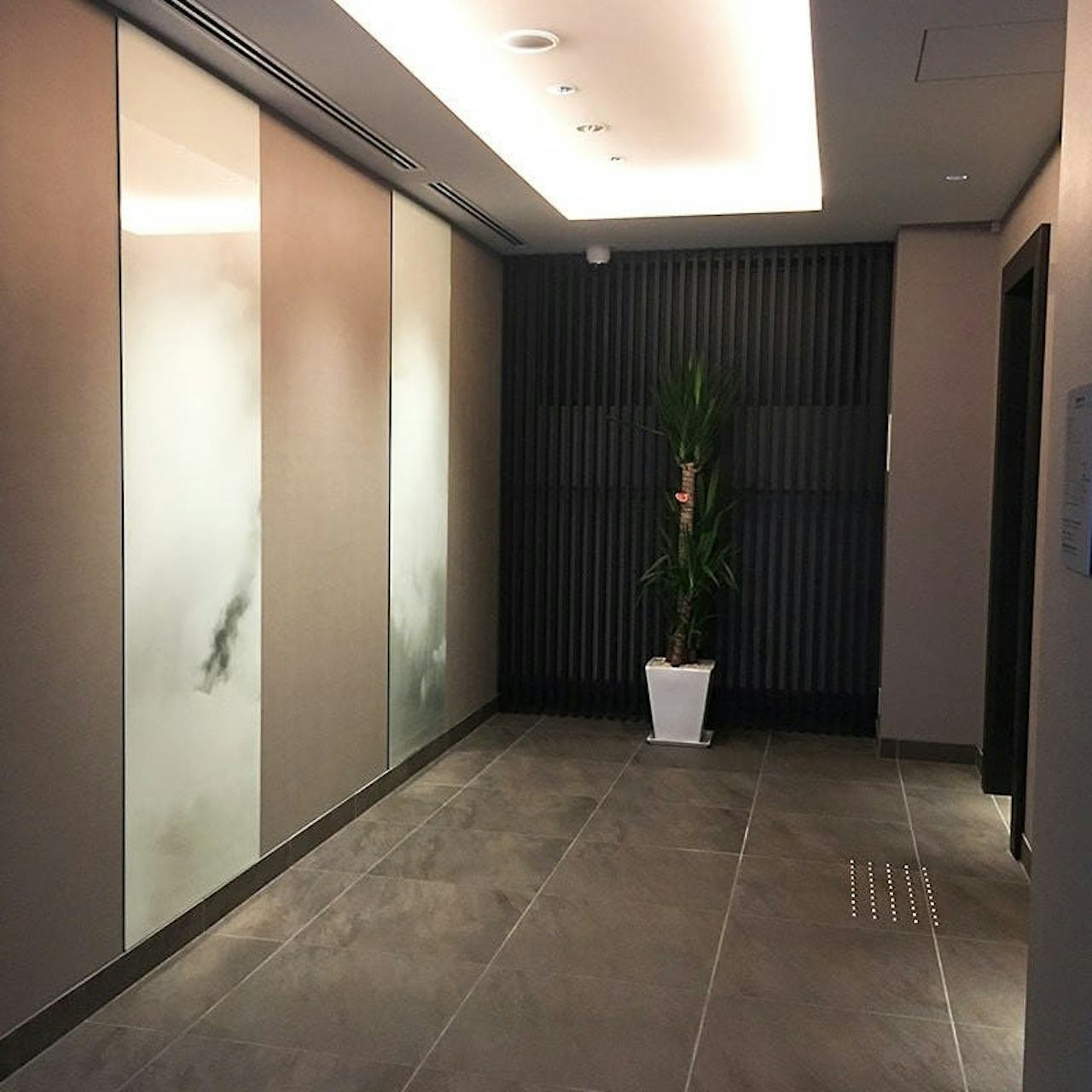 ホテルの壁面装飾に雲を印刷した鏡を設置した事例-1