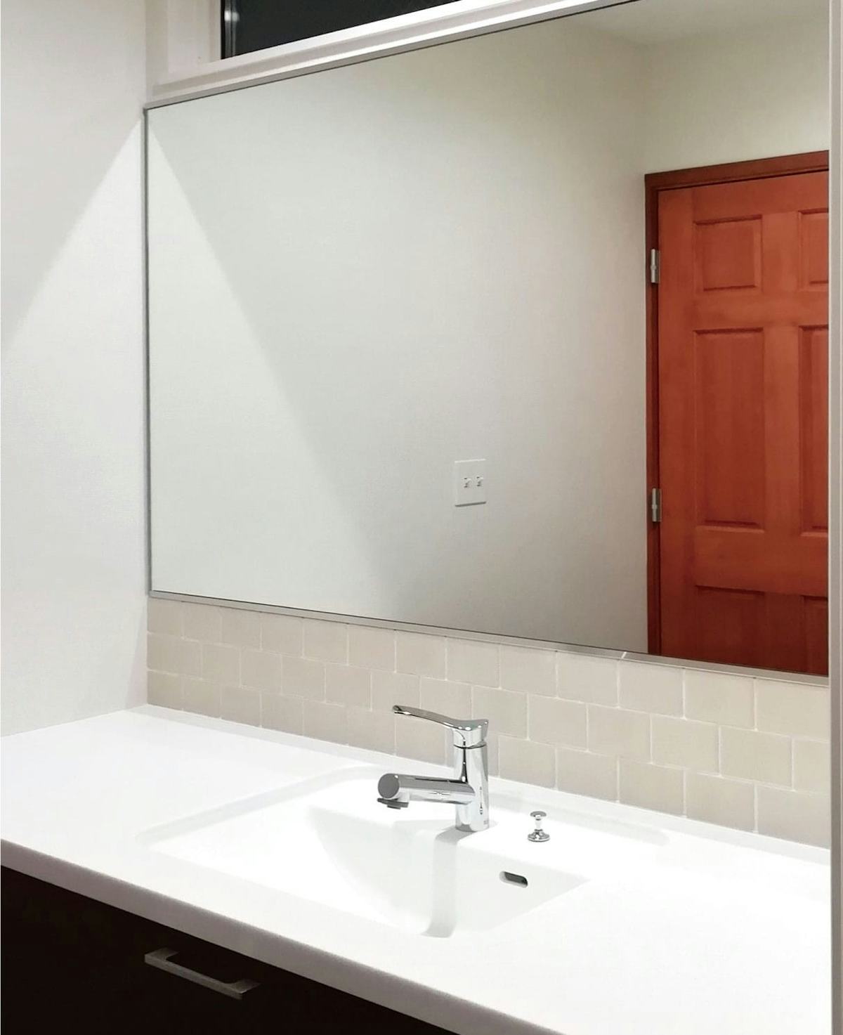 洗面所の壁いっぱいに横長鏡を設置／A様