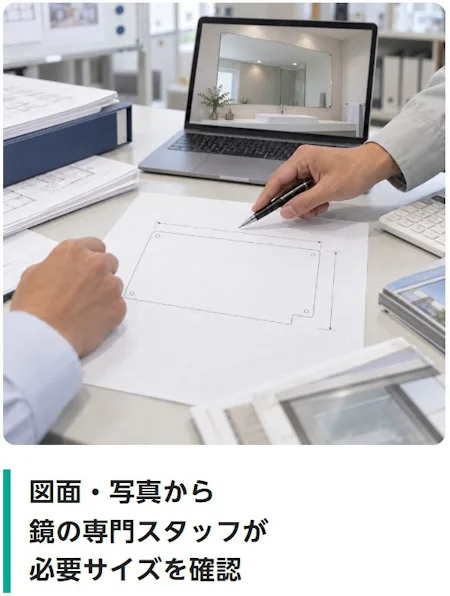 図面・写真から鏡の専門スタッフが必要サイズを確認（事務所のデスクで、手書きの鏡の図面とパソコンの写真から、サイズを確かめている様子）
