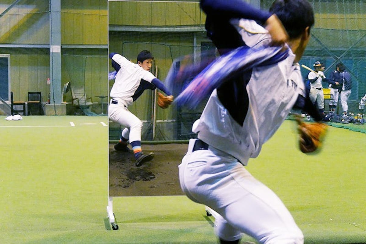 可動式鏡の前でシャドーピッチングをしている様子
